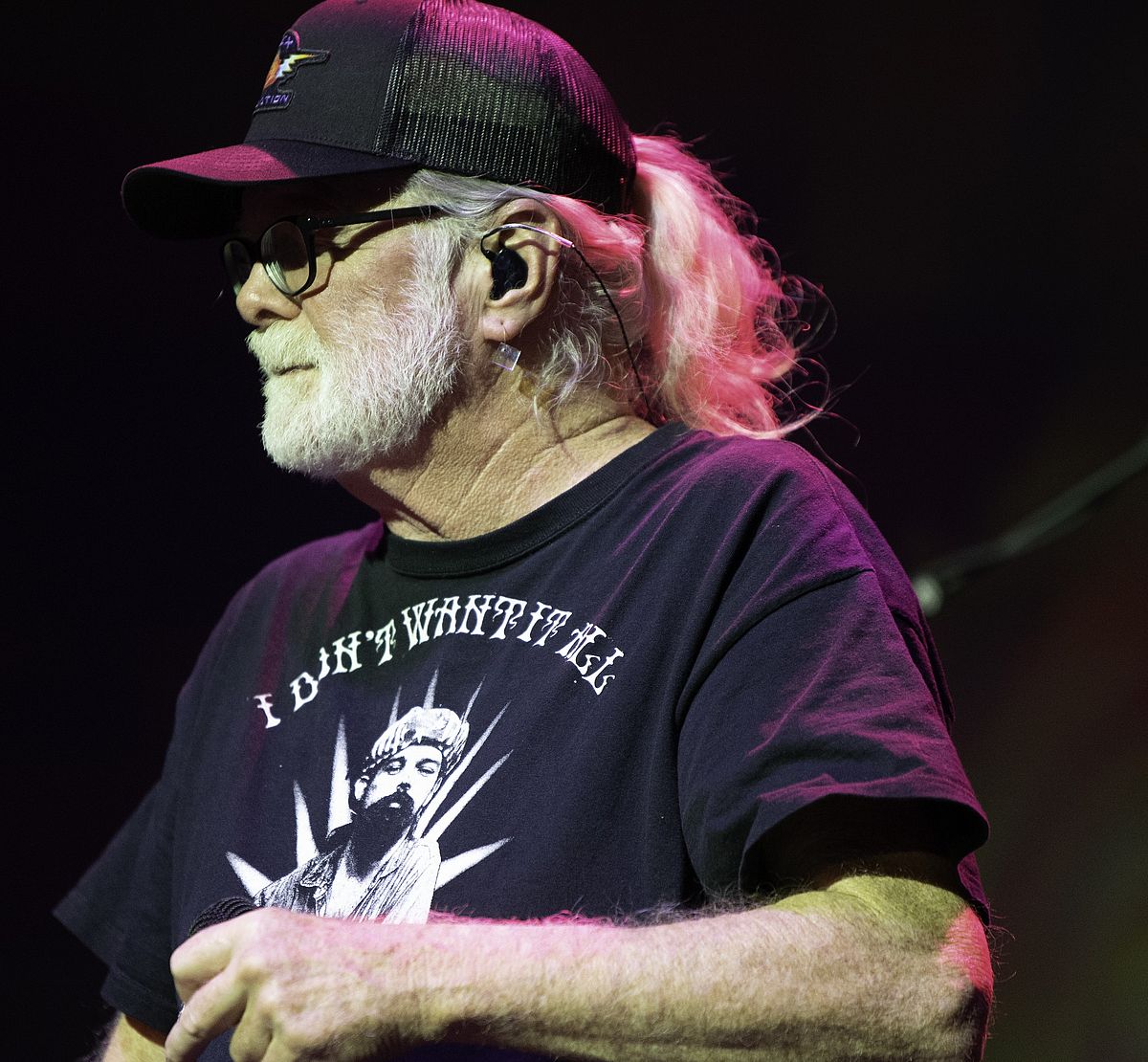 man with a black baseball hat playing in a band