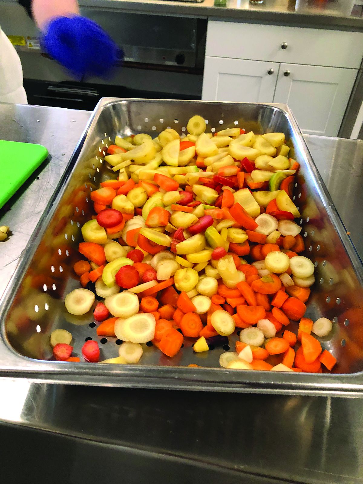 sliced carrots about to be steamed in a metal pan