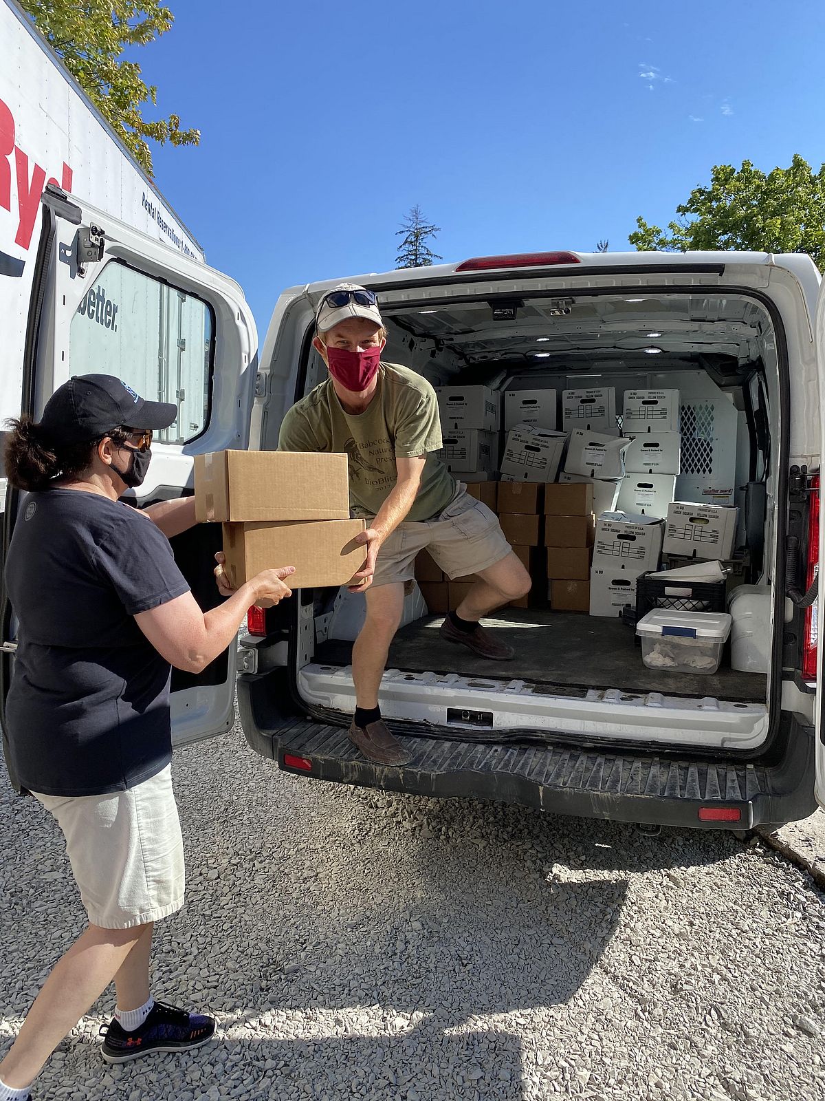 man in van is handed a box by another person