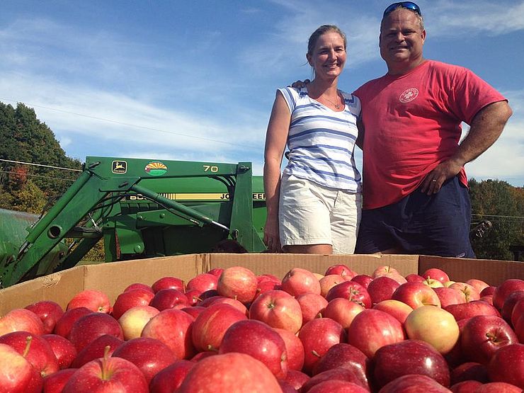 Farmers admiring their apple harvest