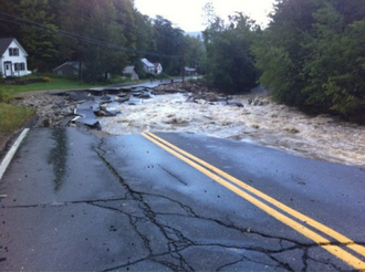 Paved road severely damaged by flooding