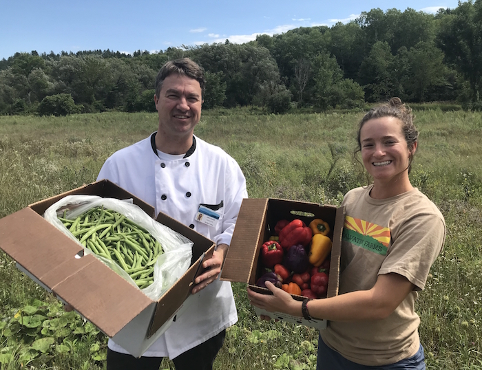 chef and farm worker proudly displaying fresh picked produce