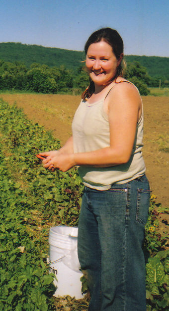 woman holds pepper in field