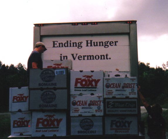 a stack of boxes in front of a truck that reads %22Ending Hunger in Vermont%22